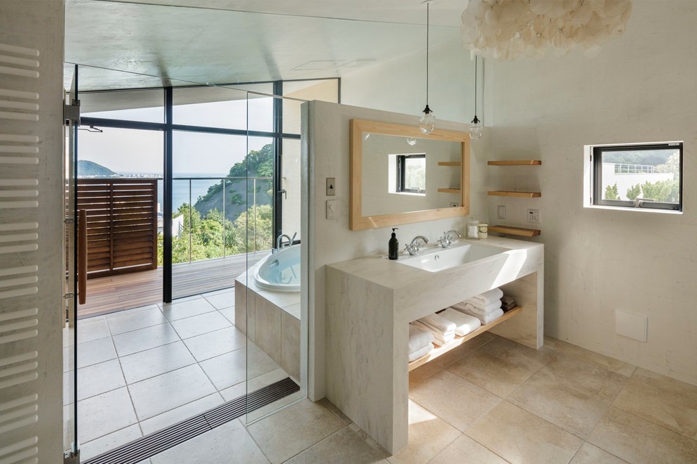 Esempio di una stanza da bagno tropicale con nessun'anta, vasca da incasso, lavabo integrato e porta doccia a battente