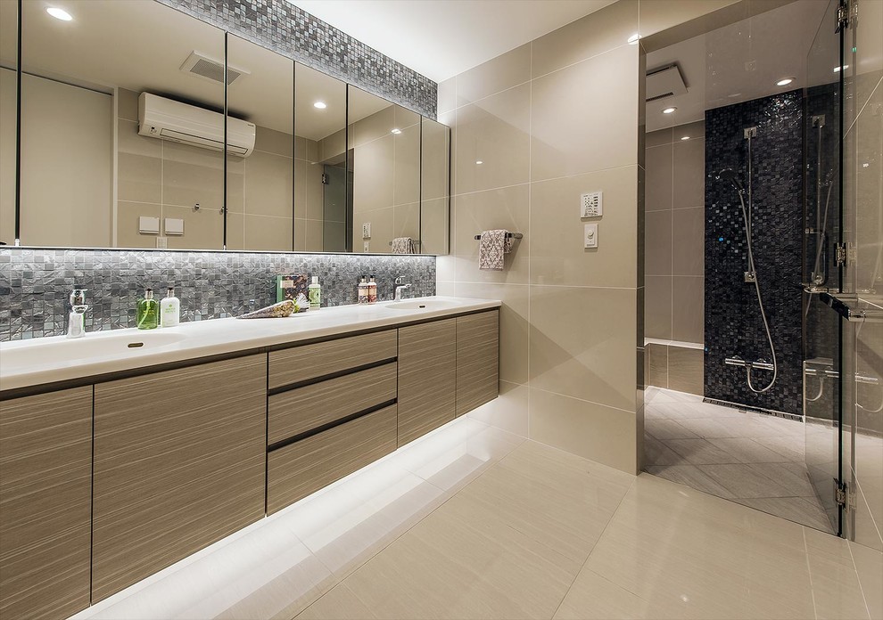 Идея дизайна: ванная комната в стиле модернизм с плоскими фасадами, светлыми деревянными фасадами, душевой комнатой, унитазом-моноблоком, бежевой плиткой, разноцветными стенами, серым полом, открытым душем и белой столешницей