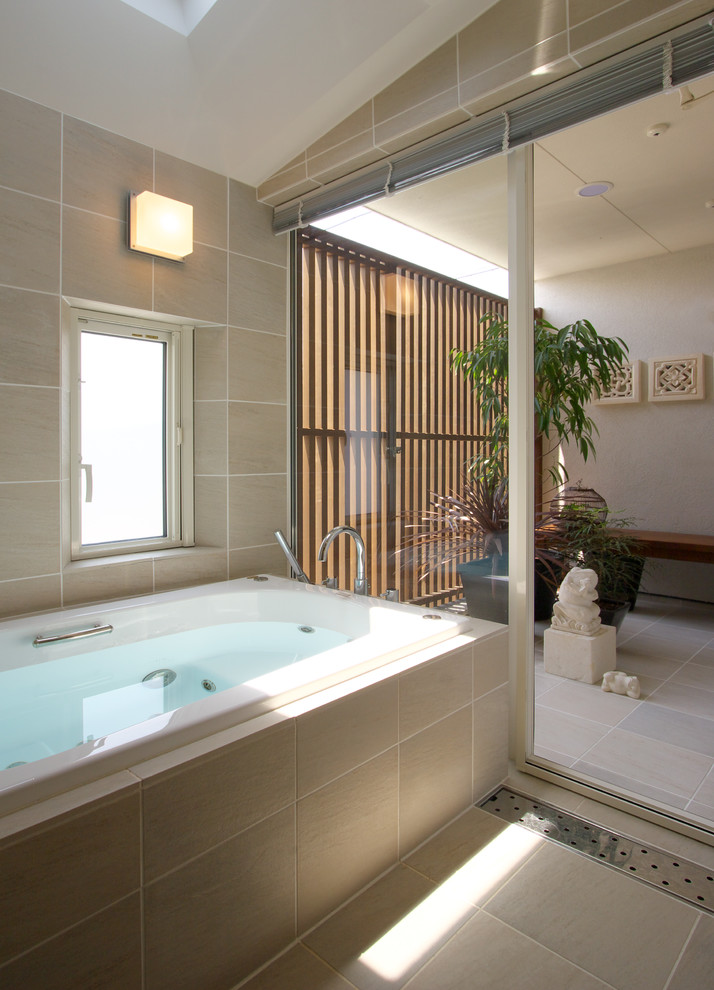 Foto di una stanza da bagno etnica con vasca ad angolo, pareti beige, pavimento marrone, piastrelle beige e piastrelle in ceramica