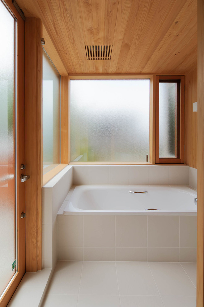 Inredning av ett minimalistiskt mellanstort en-suite badrum, med släta luckor, vita skåp, en jacuzzi, en öppen dusch, vit kakel, stickkakel, beige väggar, ljust trägolv, bänkskiva i akrylsten, beiget golv och med dusch som är öppen