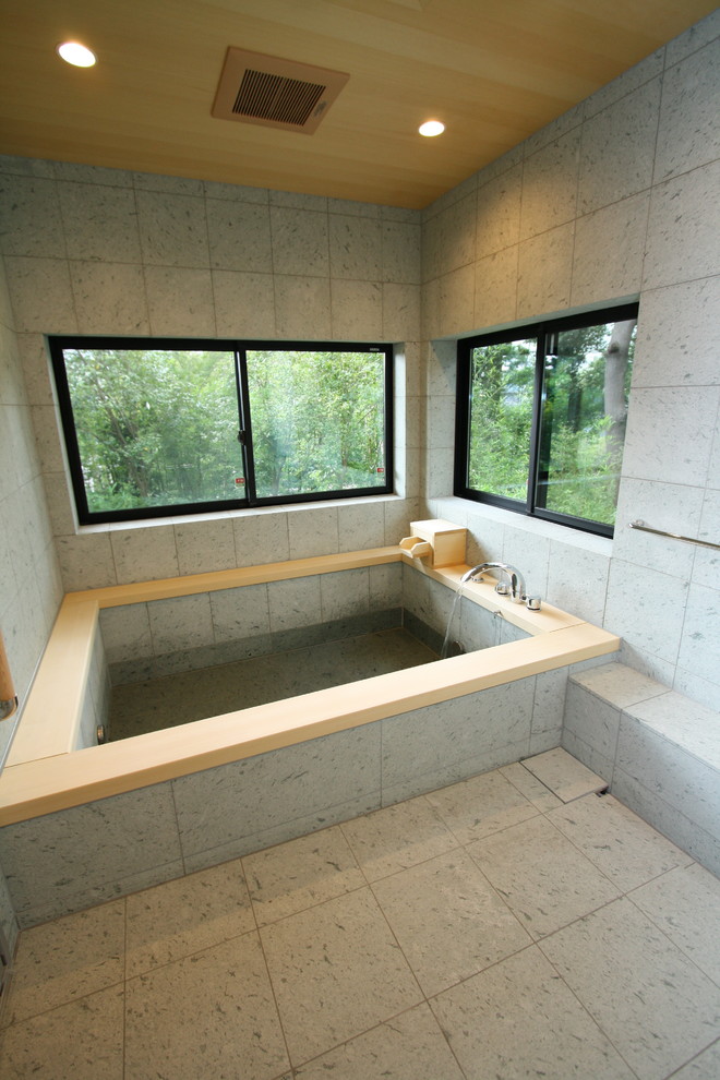 Foto de cuarto de baño principal de estilo zen con bañera japonesa, paredes grises y suelo gris