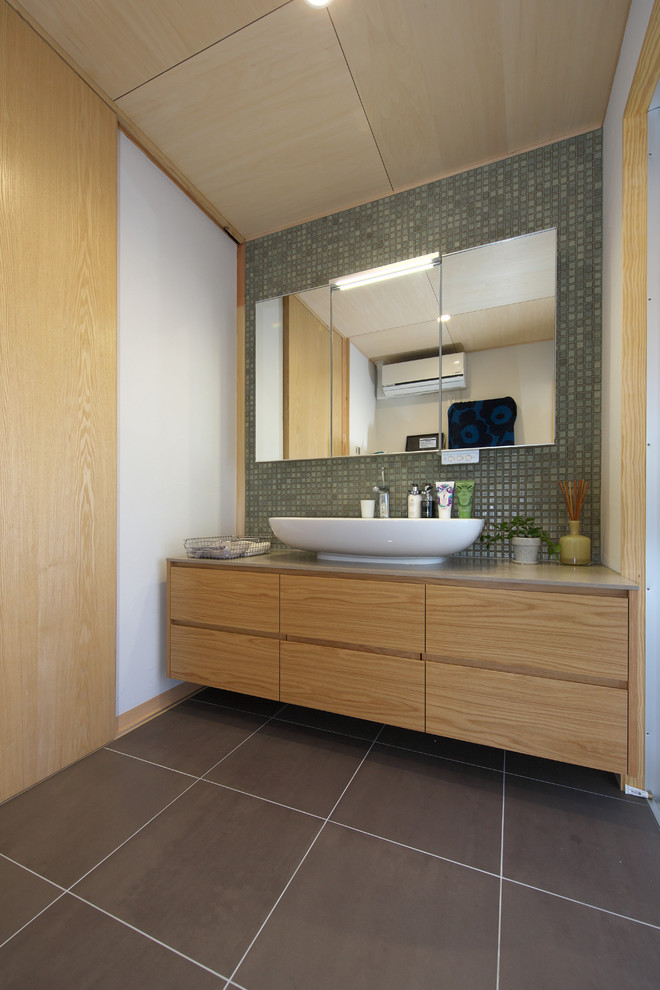 他の地域にあるアジアンスタイルのおしゃれな浴室 (フラットパネル扉のキャビネット、中間色木目調キャビネット、白い壁、ベッセル式洗面器、黒い床) の写真