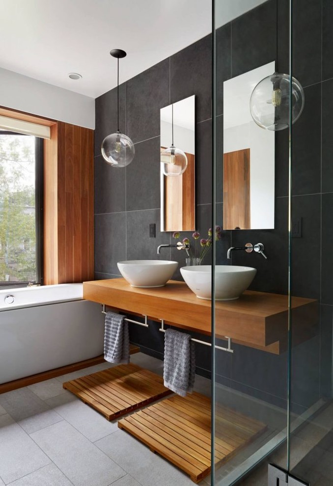Inredning av ett modernt en-suite badrum, med skåp i mellenmörkt trä, ett platsbyggt badkar, en hörndusch, svarta väggar och ett fristående handfat