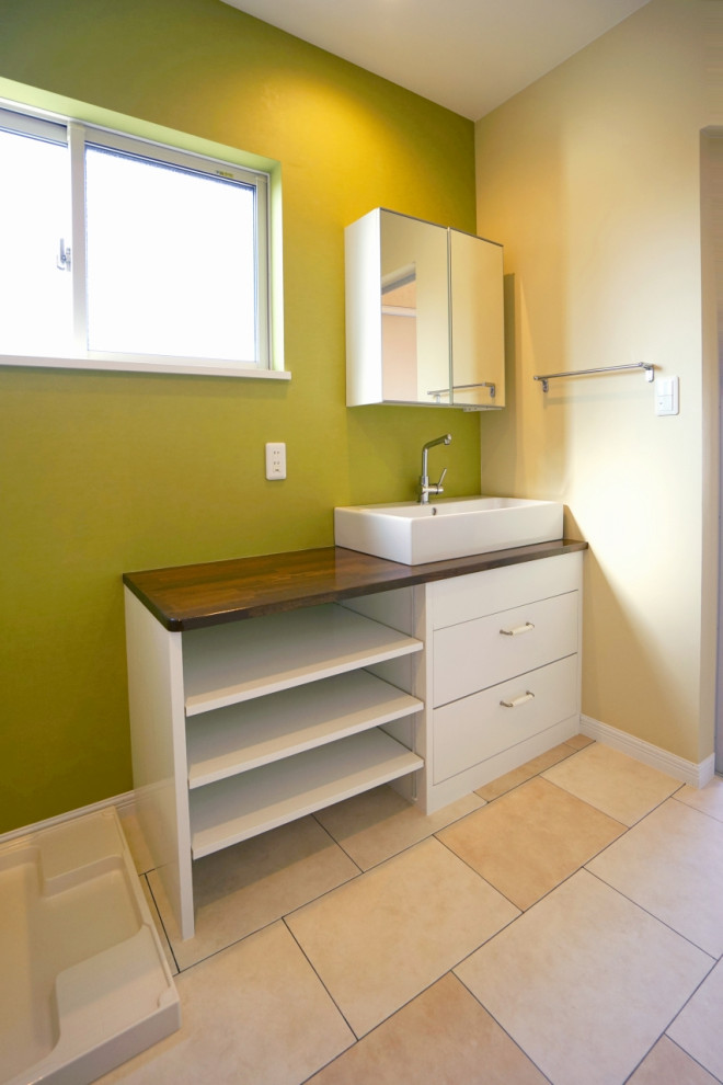 Réalisation d'un WC et toilettes nordique en bois foncé de taille moyenne avec un placard à porte plane, un plan de toilette en surface solide, un plan de toilette marron, meuble-lavabo encastré, un mur vert, un sol beige, un plafond en papier peint et du papier peint.