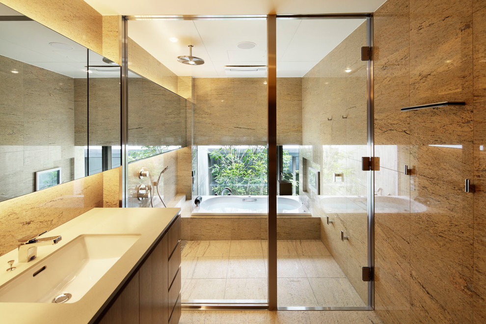 東京23区にあるコンテンポラリースタイルのおしゃれなマスターバスルーム (ドロップイン型浴槽、ダブルシャワー、大理石タイル、ベージュの壁、セラミックタイルの床、ベージュの床、白い洗面カウンター) の写真