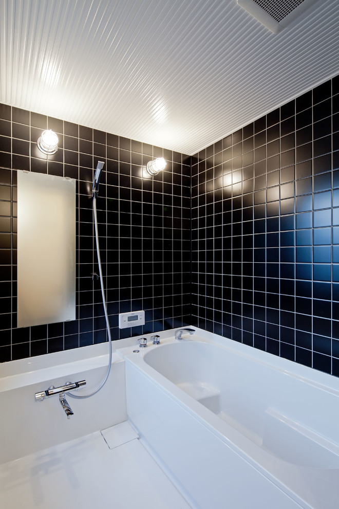 Foto de cuarto de baño minimalista con bañera esquinera, ducha abierta, paredes negras, suelo blanco y ducha abierta
