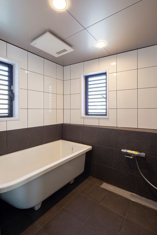 Example of a mid-sized minimalist master black and white tile and porcelain tile porcelain tile and black floor bathroom design in Tokyo with black walls