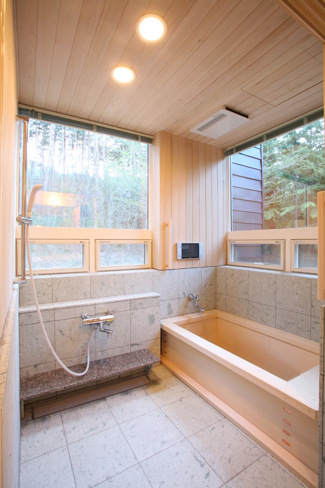 Diseño de cuarto de baño asiático sin sin inodoro con bañera japonesa, paredes beige, suelo gris, ventanas y madera
