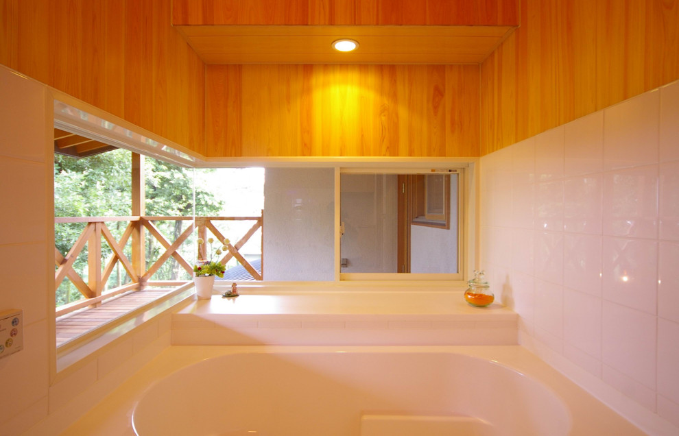 На фото: главная ванная комната среднего размера в стиле модернизм с фасадами островного типа, белыми фасадами, накладной ванной, душем над ванной, раздельным унитазом, белой плиткой, бежевыми стенами, полом из линолеума, врезной раковиной, столешницей из оникса, коричневым полом, белой столешницей, тумбой под одну раковину, встроенной тумбой, деревянным потолком и деревянными стенами с