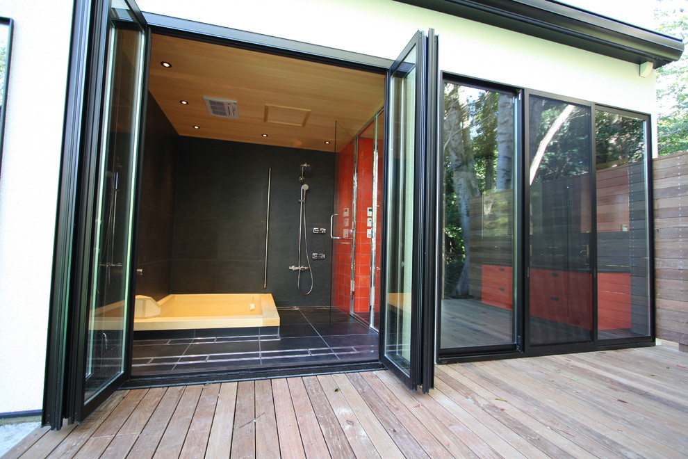 Idéer för ett asiatiskt badrum, med en jacuzzi, våtrum, svart kakel, svarta väggar, svart golv och dusch med gångjärnsdörr