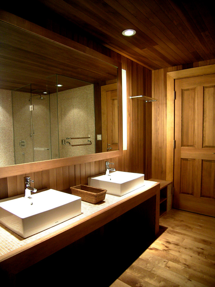 Klassisk inredning av ett stort en-suite badrum, med en jacuzzi, en dusch i en alkov, svart och vit kakel, glaskakel, bruna väggar, plywoodgolv, ett nedsänkt handfat, kaklad bänkskiva, brunt golv och dusch med gångjärnsdörr