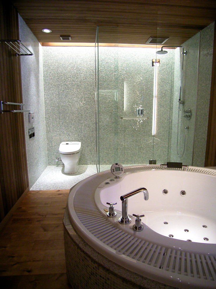 Bild på ett stort vintage en-suite badrum, med en jacuzzi, en dusch i en alkov, svart och vit kakel, glaskakel, bruna väggar, plywoodgolv, brunt golv och dusch med gångjärnsdörr