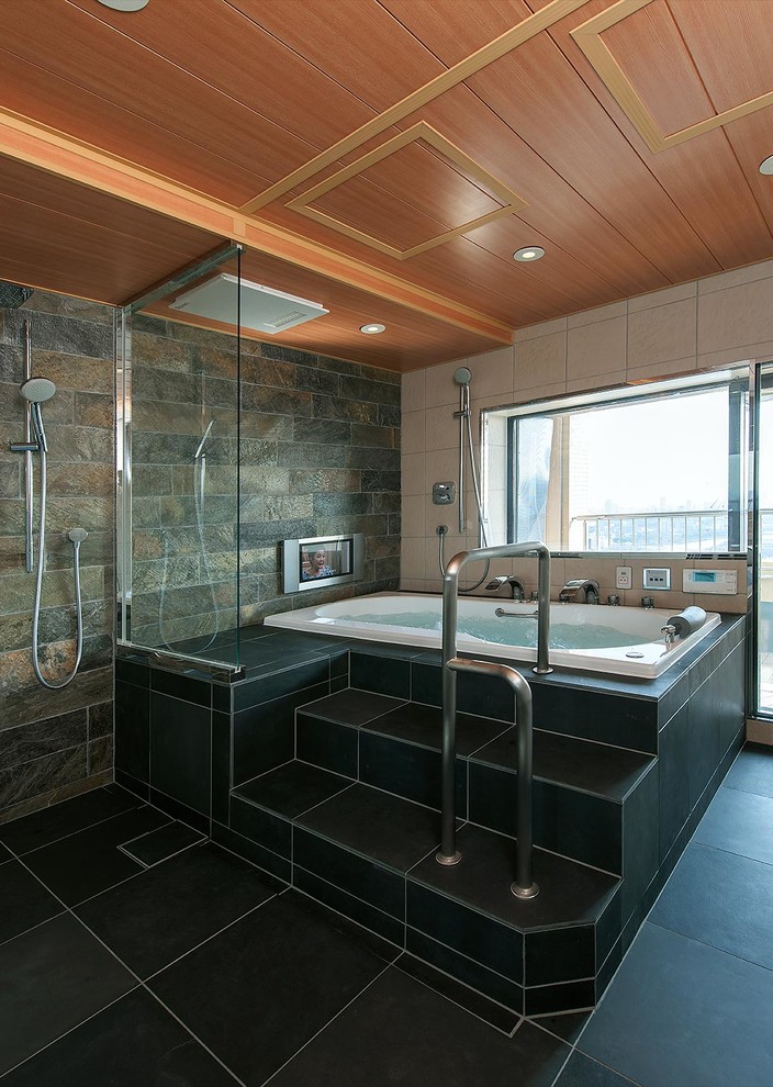 トラディショナルスタイルのおしゃれなマスターバスルーム (ドロップイン型浴槽、洗い場付きシャワー、マルチカラーのタイル、マルチカラーの壁、黒い床) の写真