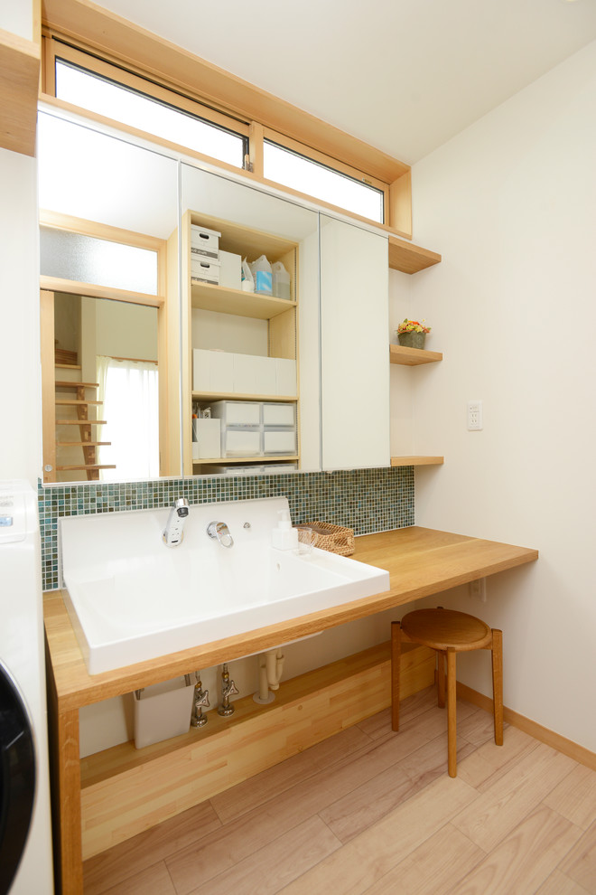 Nordisches Badezimmer mit weißer Wandfarbe, gebeiztem Holzboden, Waschtisch aus Holz, braunem Boden und brauner Waschtischplatte in Sonstige