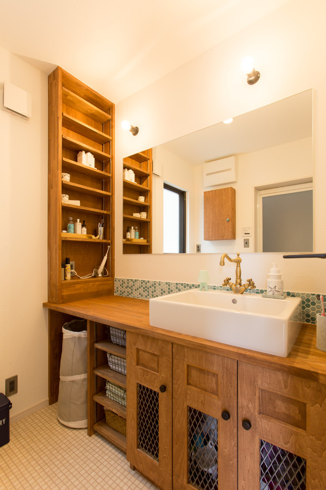 他の地域にあるアジアンスタイルのおしゃれな浴室 (オープンシェルフ、中間色木目調キャビネット、白い壁、ベッセル式洗面器、木製洗面台、ベージュの床、ブラウンの洗面カウンター) の写真
