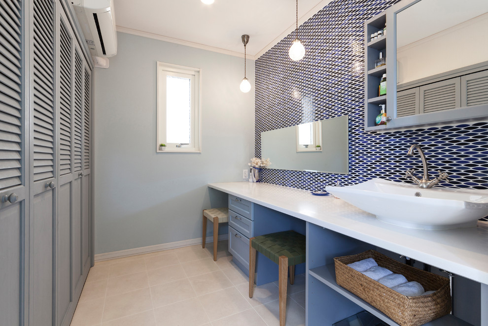 名古屋にあるトランジショナルスタイルのおしゃれな浴室 (落し込みパネル扉のキャビネット、青いキャビネット、青いタイル、青い壁、ベッセル式洗面器、ベージュの床、白い洗面カウンター) の写真