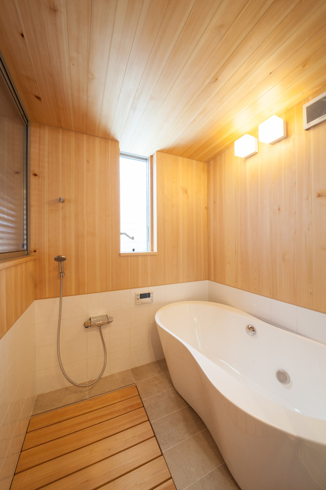 Asiatisches Badezimmer En Suite mit freistehender Badewanne, bodengleicher Dusche und weißen Fliesen in Sonstige