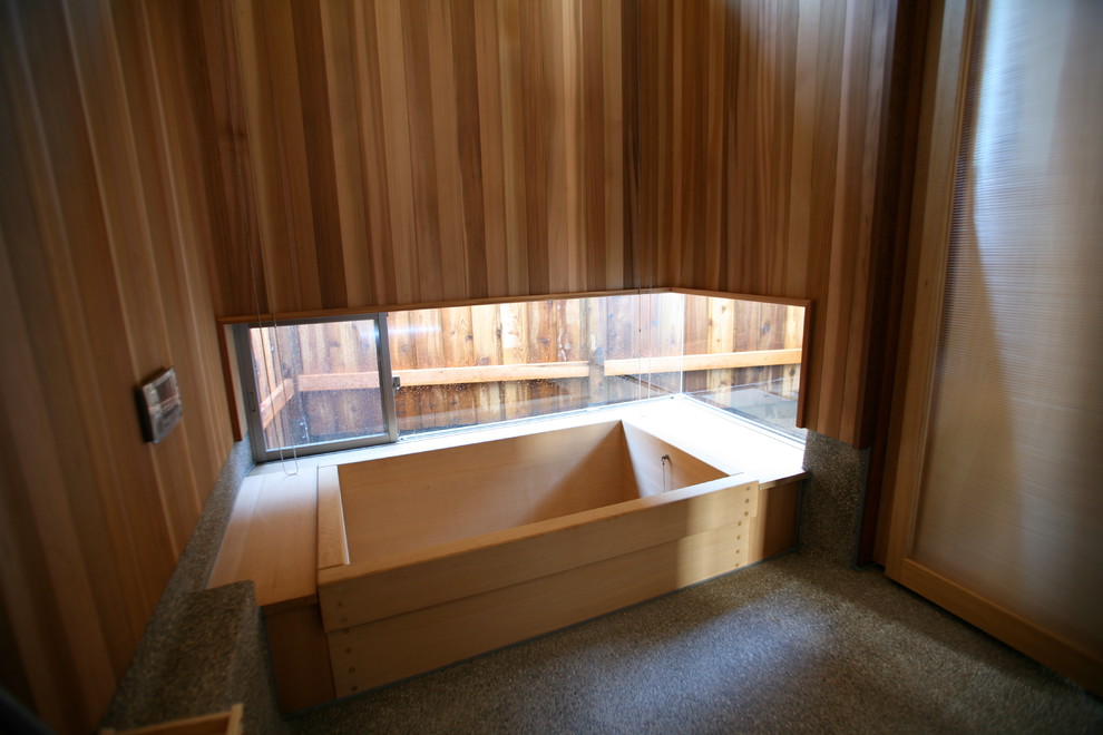 Foto di una stanza da bagno etnica di medie dimensioni con vasca giapponese, pavimento grigio e pareti in legno