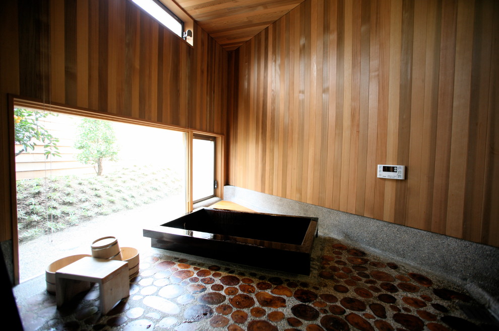На фото: ванная комната в восточном стиле с японской ванной, окном, деревянным потолком и деревянными стенами с