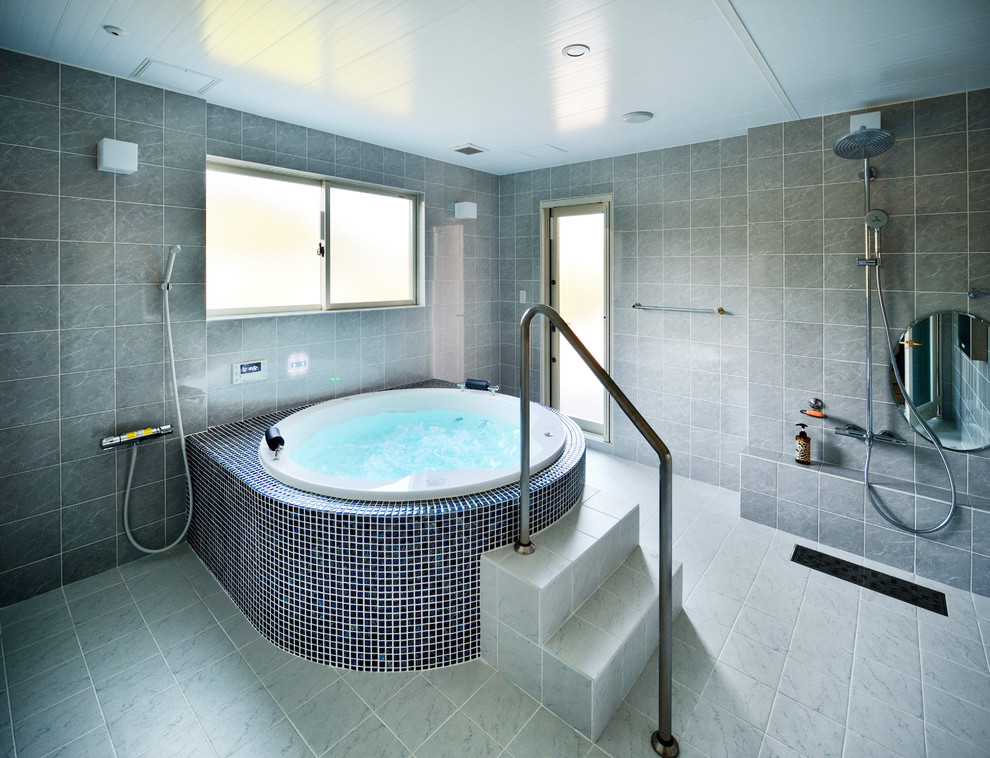 Идея дизайна: большая главная ванная комната в викторианском стиле с гидромассажной ванной, открытым душем, серой плиткой, плиткой из известняка, серыми стенами, столешницей из известняка, душем с распашными дверями и серой столешницей