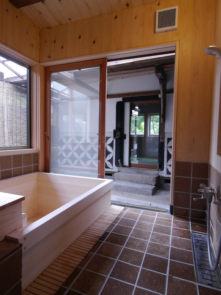 Immagine di una stanza da bagno padronale etnica con vasca giapponese, piastrelle marroni, pareti beige, pareti in legno e zona vasca/doccia separata