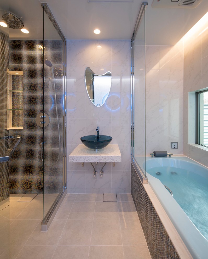Réalisation d'une douche en alcôve design avec une baignoire d'angle, un mur multicolore, une vasque, un sol beige et une cabine de douche à porte coulissante.