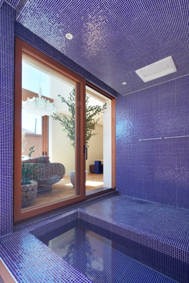 Ejemplo de cuarto de baño mediterráneo con bañera encastrada, baldosas y/o azulejos azules, paredes azules y suelo azul