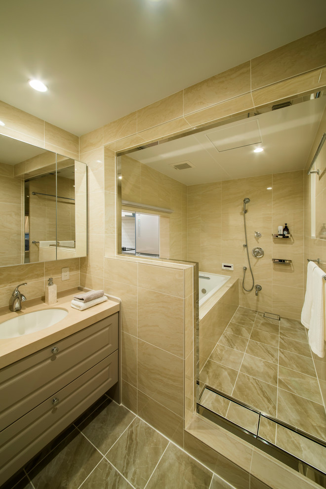 На фото: ванная комната в средиземноморском стиле с бежевыми фасадами, открытым душем, бежевыми стенами, монолитной раковиной, коричневым полом и открытым душем
