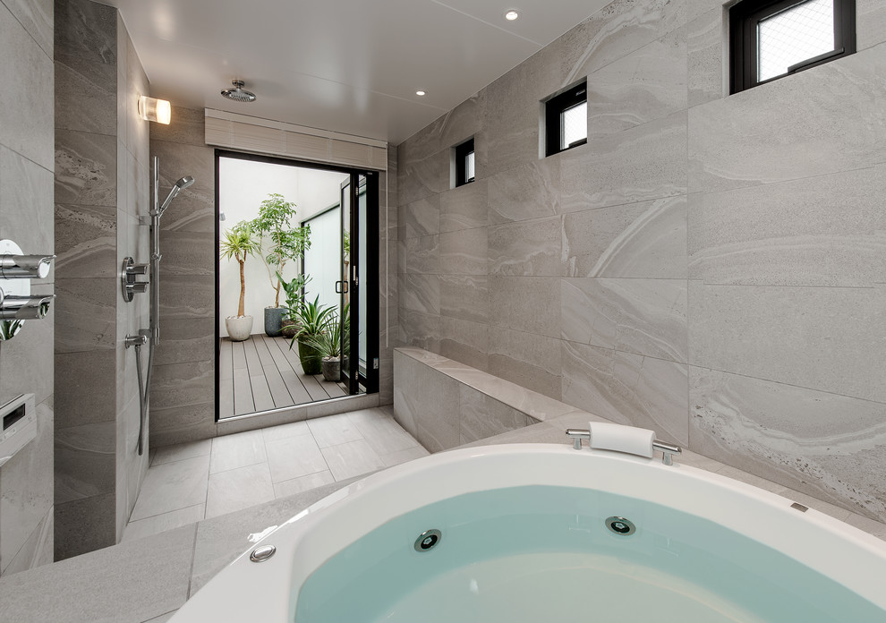 Inredning av ett modernt badrum, med en öppen dusch, grå väggar, grått golv och med dusch som är öppen