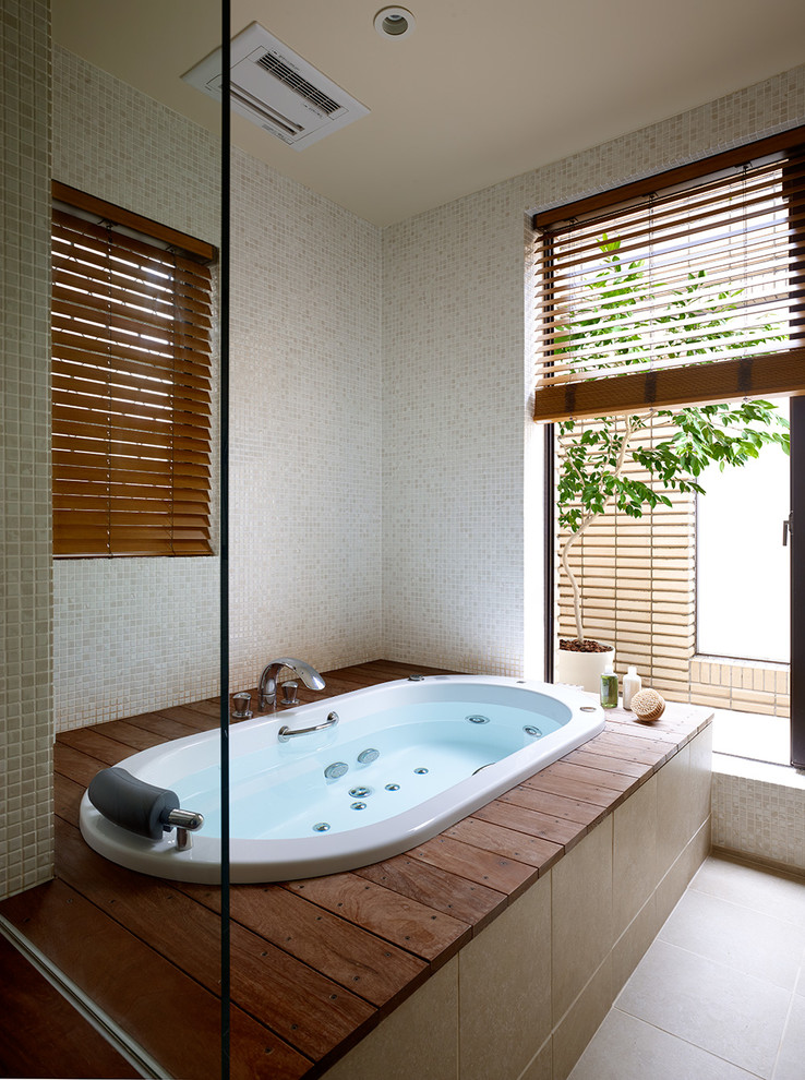 東京23区にあるアジアンスタイルのおしゃれな浴室 (ドロップイン型浴槽、ベージュのタイル、セラミックタイル、ベージュの壁、セラミックタイルの床) の写真