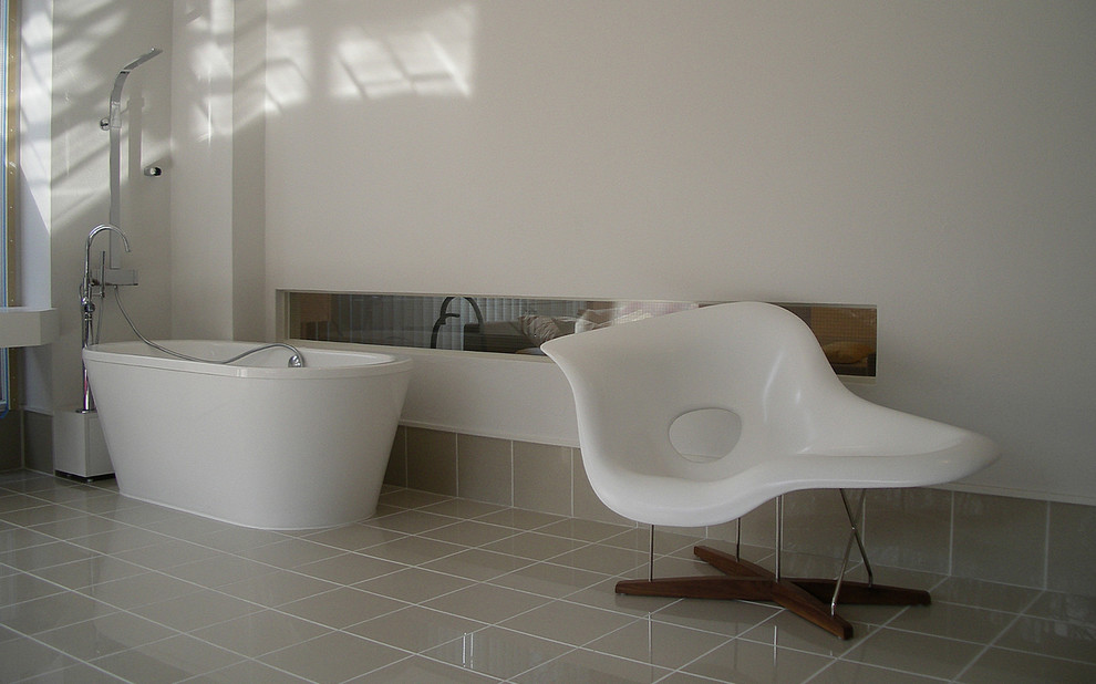 Foto di una stanza da bagno minimalista con vasca freestanding, vasca/doccia, piastrelle beige e pareti bianche
