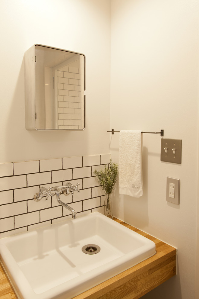 東京23区にあるコンテンポラリースタイルのおしゃれな浴室 (白いタイル、サブウェイタイル、白い壁、木製洗面台、ブラウンの洗面カウンター) の写真