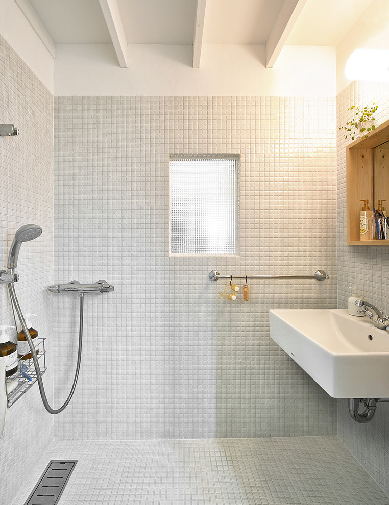 Foto di una stanza da bagno contemporanea con piastrelle grigie, pareti grigie, pavimento con piastrelle in ceramica, lavabo sospeso e pavimento grigio