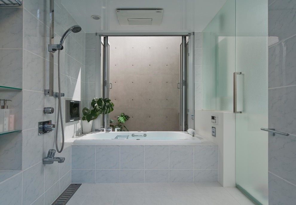 Cette photo montre une salle de bain moderne avec une baignoire d'angle, un mur bleu, un sol blanc et aucune cabine.