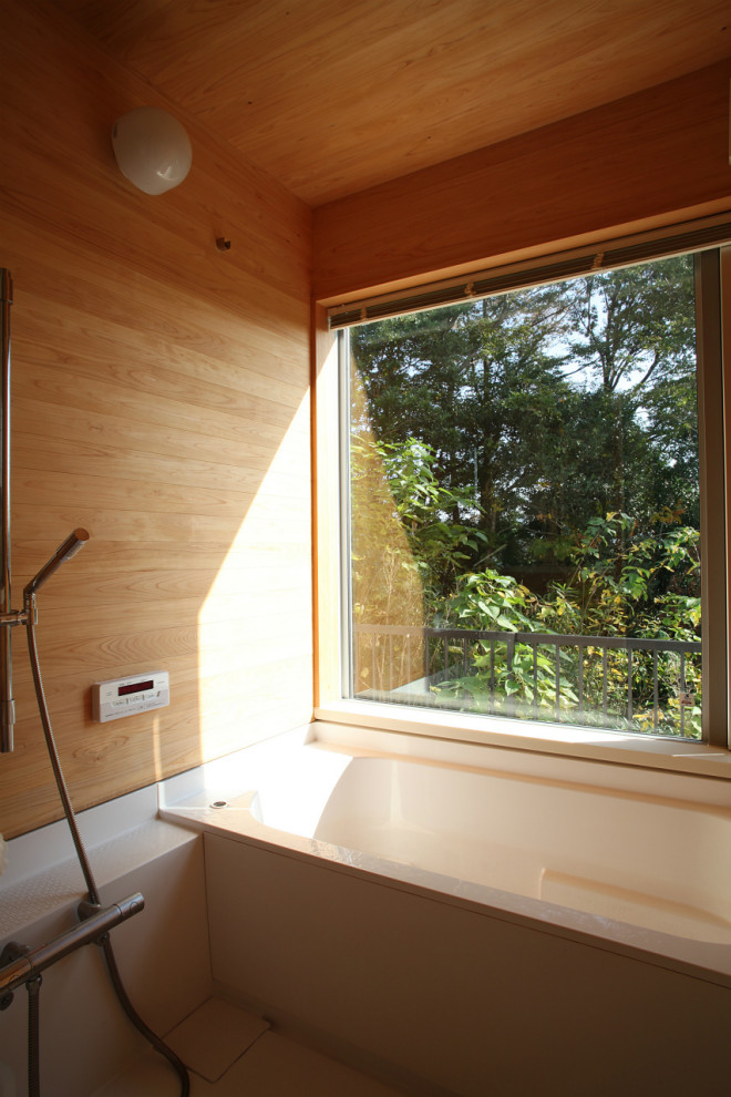 Foto di una piccola stanza da bagno padronale etnica con vasca giapponese, vasca/doccia, piastrelle marroni, pareti marroni, pavimento bianco e doccia aperta