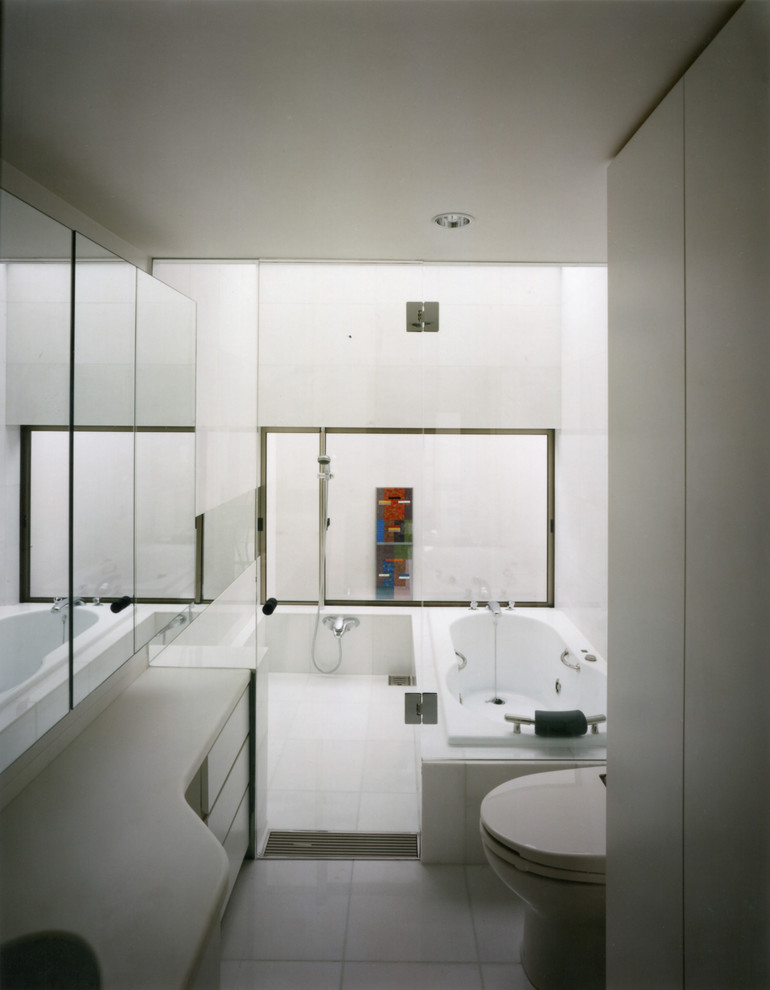 Idéer för att renovera ett mellanstort orientaliskt vit vitt en-suite badrum, med luckor med profilerade fronter, vita skåp, ett platsbyggt badkar, en dusch/badkar-kombination, en toalettstol med hel cisternkåpa, vit kakel, marmorkakel, vita väggar, marmorgolv, ett undermonterad handfat, bänkskiva i akrylsten, vitt golv och dusch med gångjärnsdörr