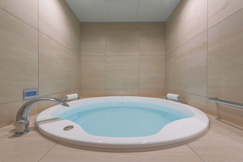 Foto di una stanza da bagno con vasca idromassaggio, piastrelle beige, piastrelle in gres porcellanato, pareti beige, pavimento in sughero e pavimento marrone