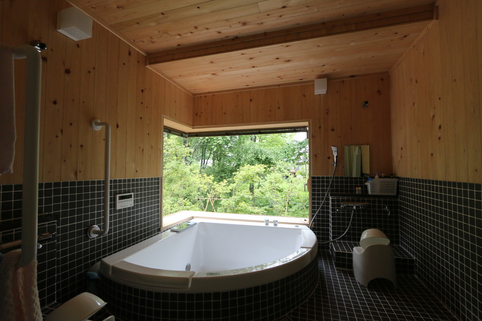 Стильный дизайн: ванная комната в современном стиле с гидромассажной ванной, черной плиткой и черными стенами - последний тренд