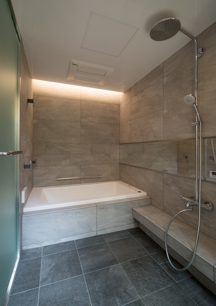 Imagen de cuarto de baño rectangular moderno con bañera esquinera, ducha abierta, paredes beige, suelo negro y ducha abierta