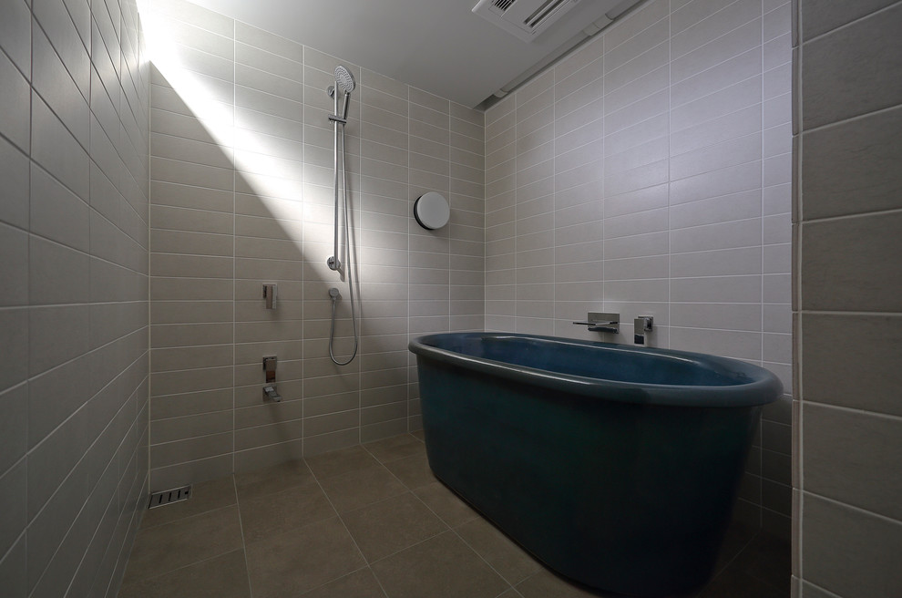 Inspiration för ett funkis badrum, med ett fristående badkar, beige kakel och grå väggar
