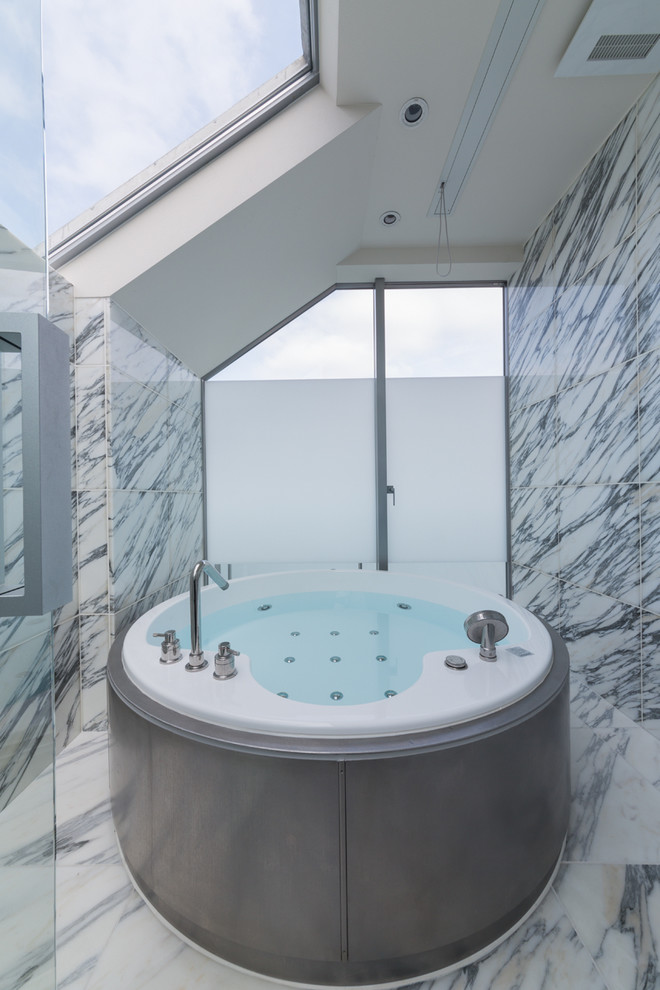 Foto på ett funkis badrum, med ett fristående badkar, en öppen dusch, grå väggar, marmorgolv, grått golv och med dusch som är öppen