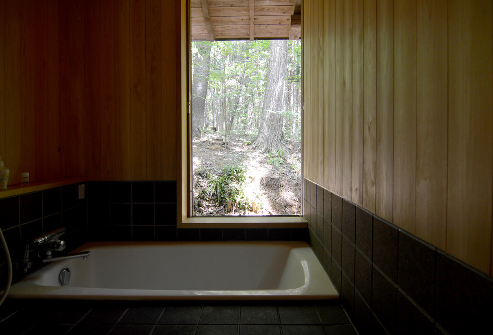 Cette image montre une petite salle de bain asiatique avec un sol en liège, un carrelage noir, un mur marron et un sol noir.