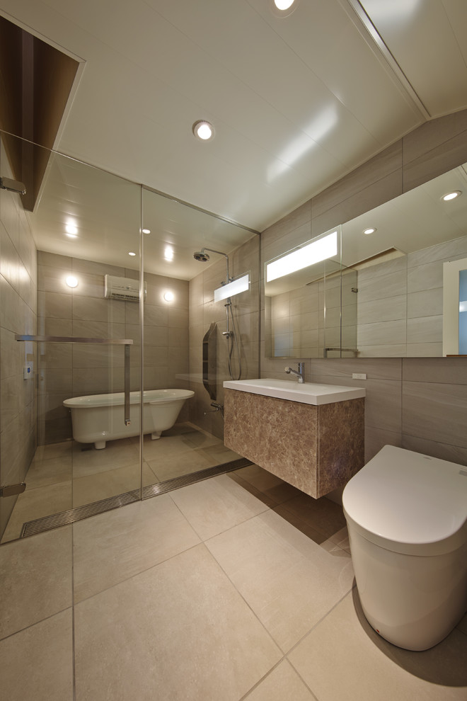 На фото: большая главная ванная комната в восточном стиле с плоскими фасадами, оранжевыми фасадами, ванной на ножках, двойным душем, унитазом-моноблоком, серой плиткой, керамической плиткой, серыми стенами, полом из керамогранита, подвесной раковиной, столешницей из искусственного камня, белым полом и душем с распашными дверями