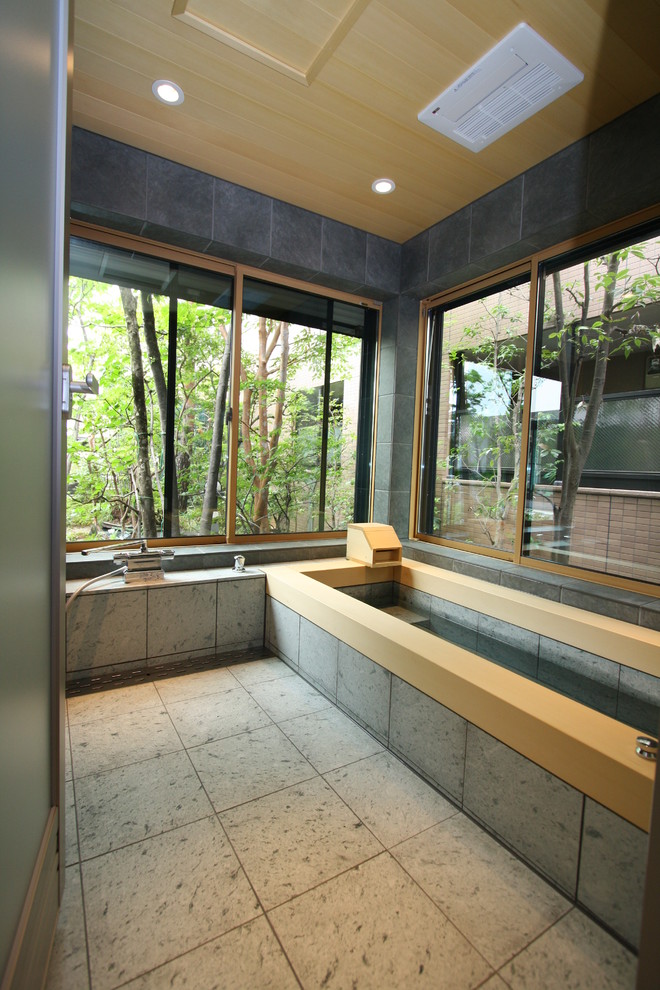 На фото: ванная комната в восточном стиле с душем без бортиков, серой плиткой, керамической плиткой, серыми стенами, полом из керамической плитки, ванной в нише и окном