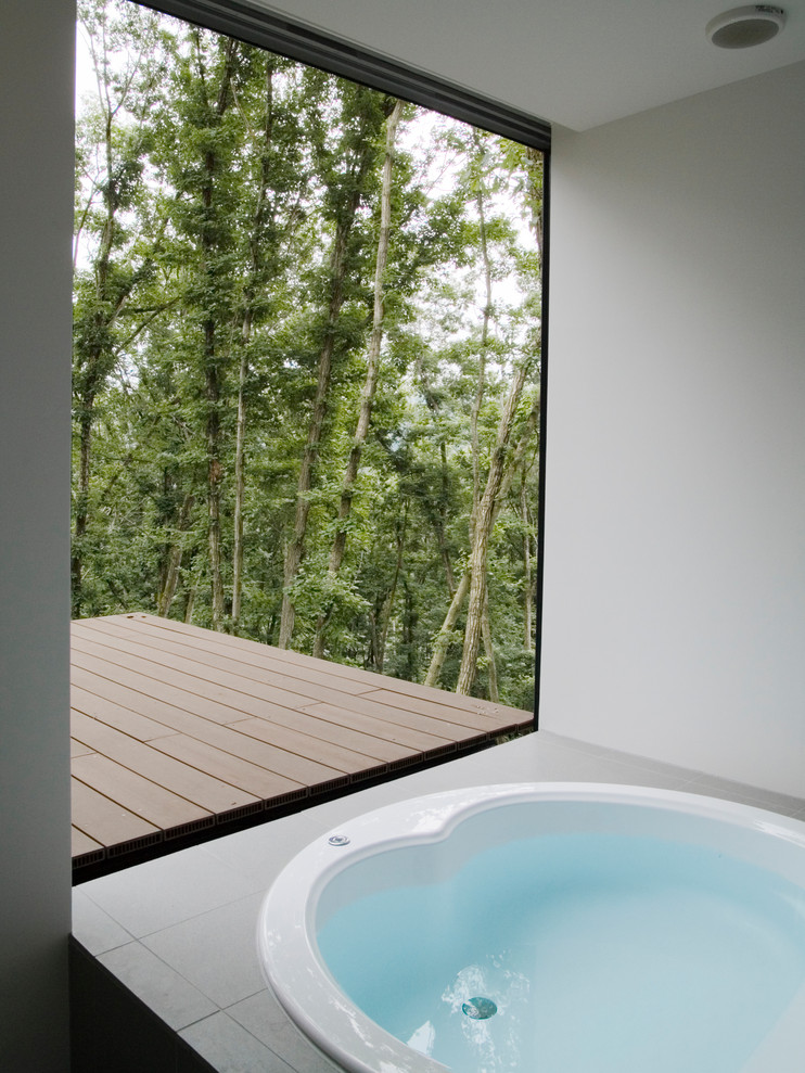 Idee per una stanza da bagno padronale minimalista di medie dimensioni con vasca idromassaggio, piastrelle bianche, pareti bianche, pavimento con piastrelle in ceramica, pavimento grigio e porta doccia a battente