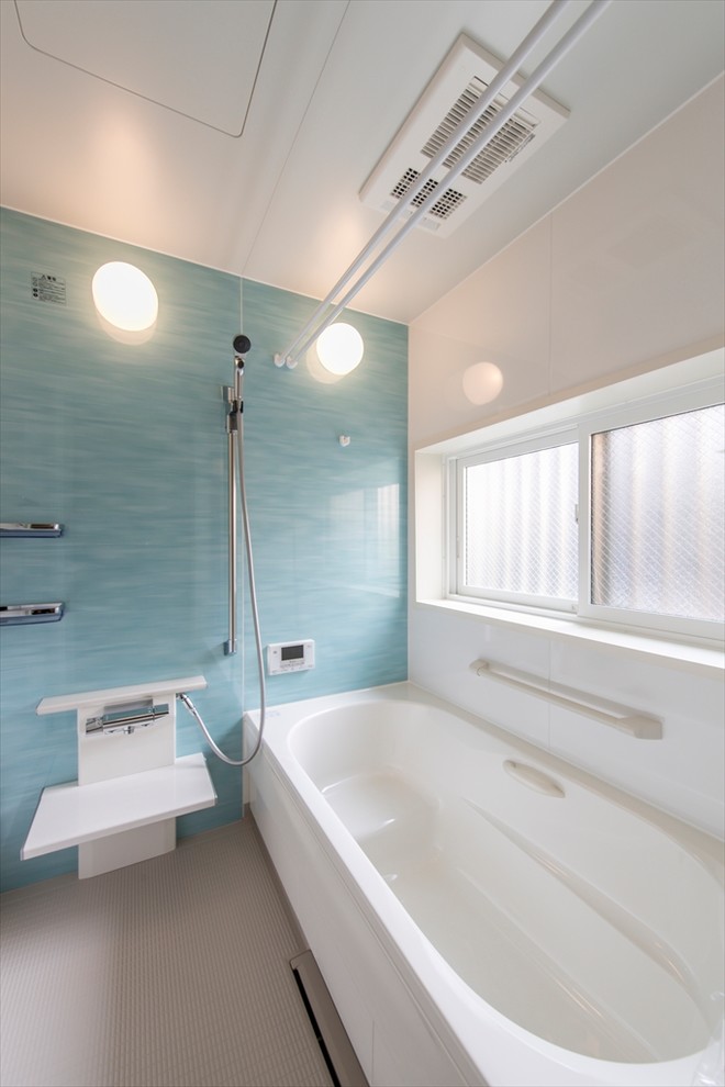 Aménagement d'une salle de bain moderne avec un mur bleu et un sol gris.
