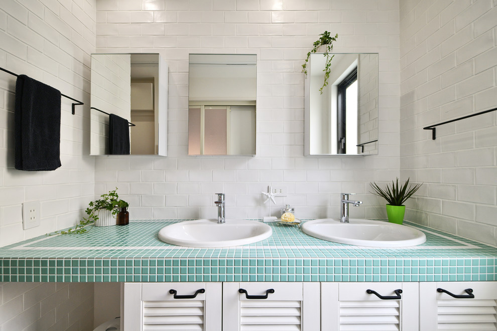 Стильный дизайн: ванная комната в скандинавском стиле с фасадами с филенкой типа жалюзи, белыми фасадами, белыми стенами, накладной раковиной, столешницей из плитки и синей столешницей - последний тренд