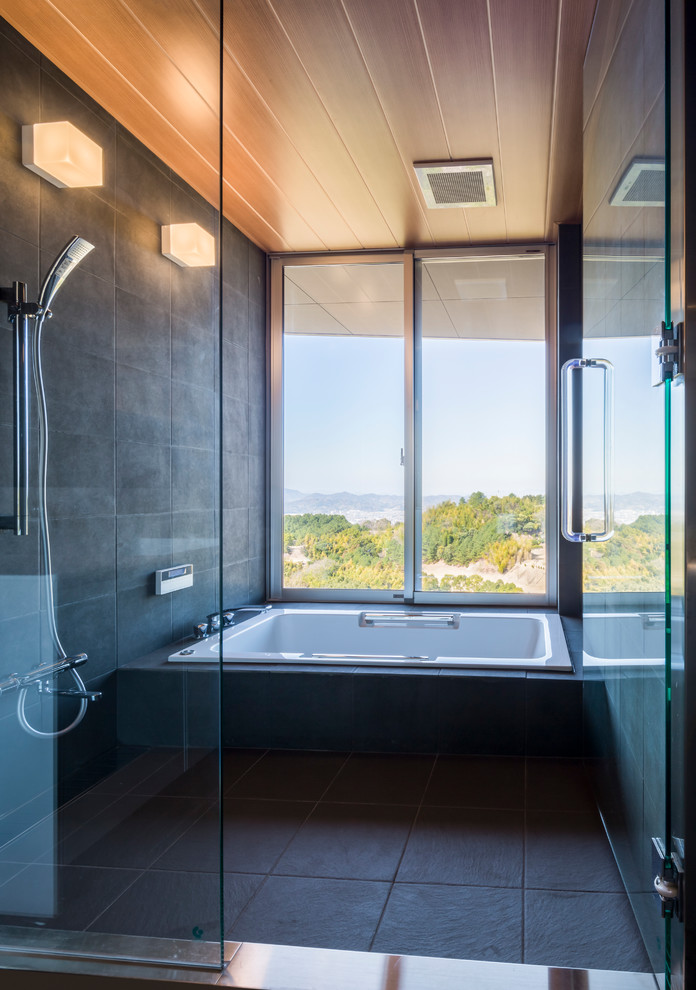 На фото: ванная комната в стиле модернизм с угловой ванной, открытым душем, серыми стенами, серым полом и открытым душем