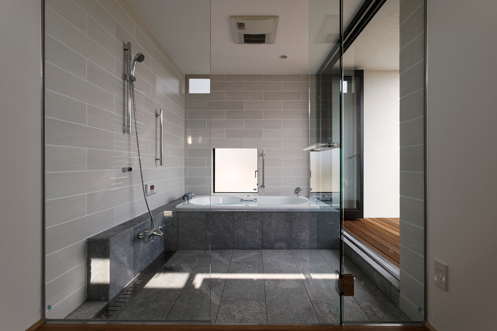 東京23区にある高級な中くらいなコンテンポラリースタイルのおしゃれなマスターバスルーム (大型浴槽、グレーのタイル、アルコーブ型シャワー、グレーの床、ベージュの壁、セラミックタイルの床) の写真