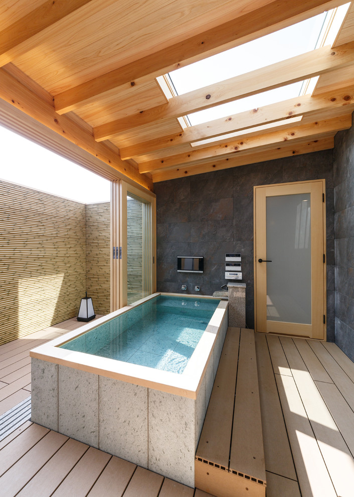 Asiatisches Badezimmer mit freistehender Badewanne, grauer Wandfarbe und braunem Boden in Sonstige